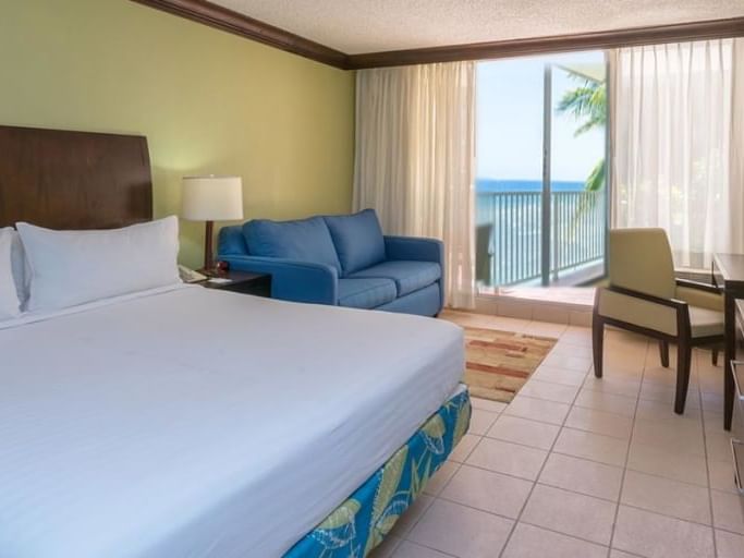 Sofa by the king bed & balcony overlooking the sea in Superior Room at Holiday Inn Montego Bay