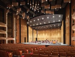 National Arts Centre with warm wooden walls, rows of red-upholstered seats, and a stage near ReStays Ottawa