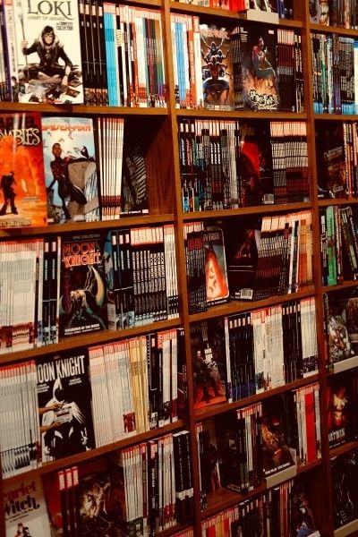 A wooden bookshelf filled with a variety of comic books.