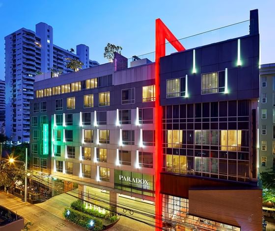 Modern exterior of the Paradox Bangkok hotel with its distinctive red architectural feature at Paradox Hotels and Resorts