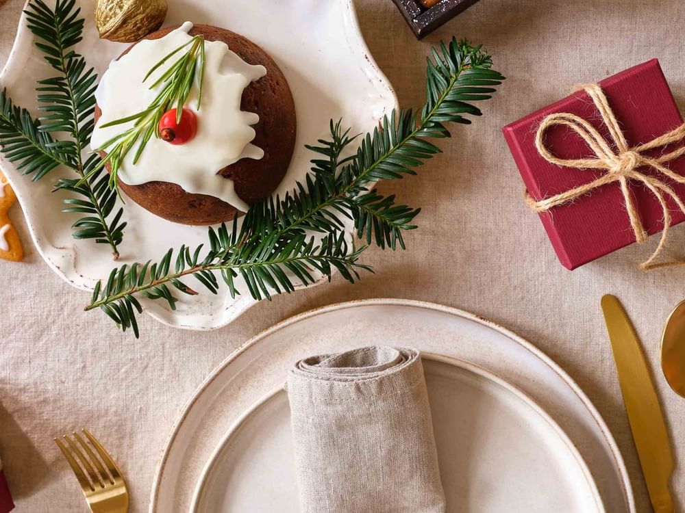 Christmas pudding on decorated table with gold and red decor