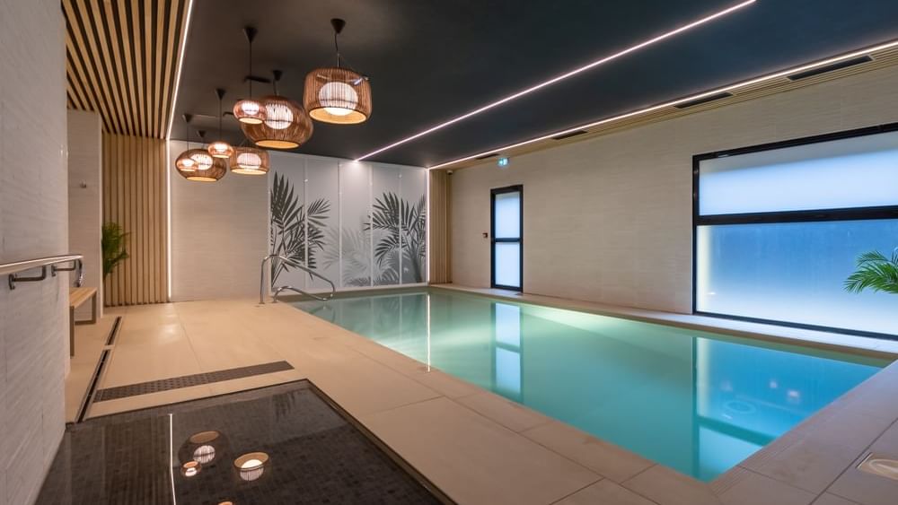 A splendid indoor pool & hanging lamps at ​​Originals Hotels