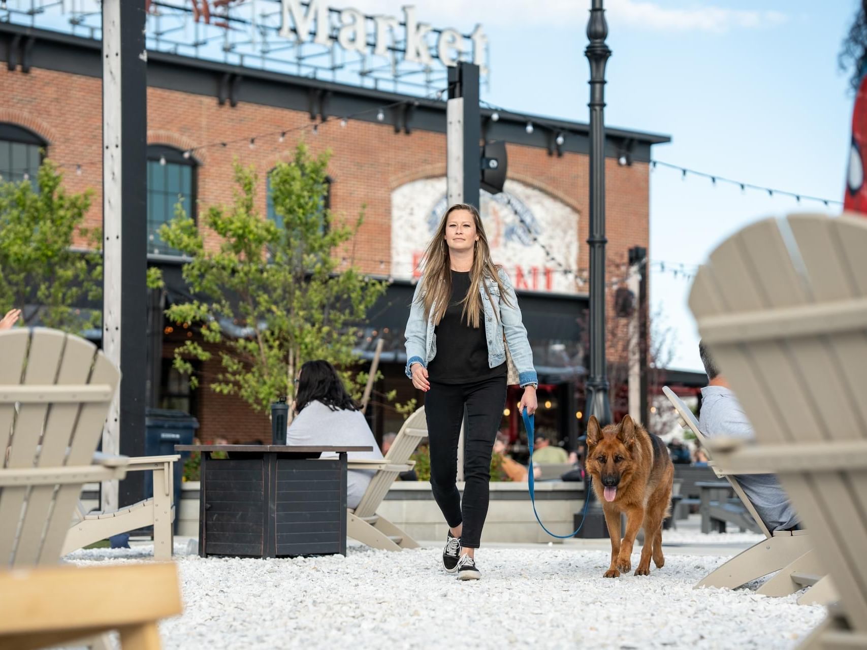 Woman walking a German Shepherd dog in Tuscan village near The Artisan Hotel at Tuscan Village