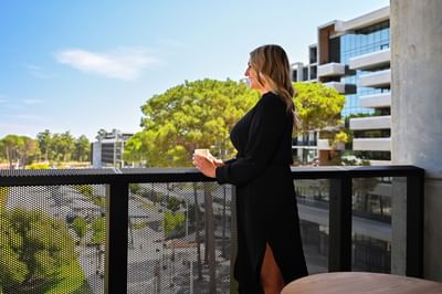 Lady overlooking city from the balcony at Nesuto Curtin Perth