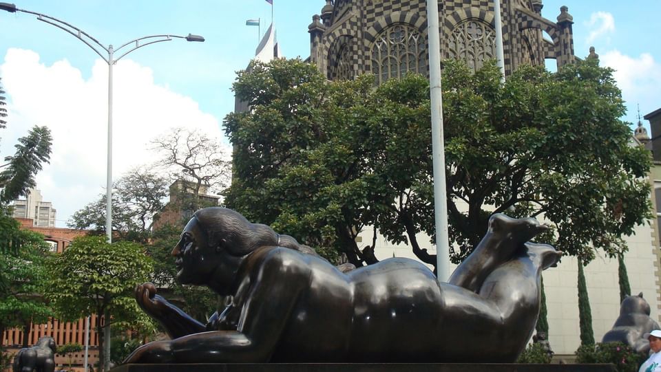 Statue of woman laying in Plaza Botero, Le Manoir Egina Hotels