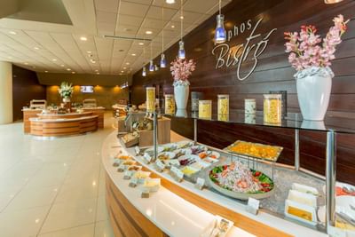 Interior of Delphos Bistro featuring a curved buffet with dishes and elegant decor at Hotel Los Delfines & Casino