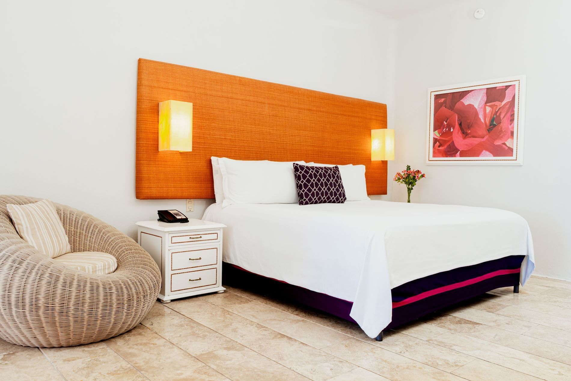 Nightstand and cozy lounge chair by the bed with cushioned headboard in King Deluxe Bed at Camino Real Zaashila Huatulco