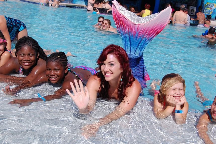 Mermaid  featuring a blue and pink fin swimming with happy children at Margaritaville Resort Biloxi