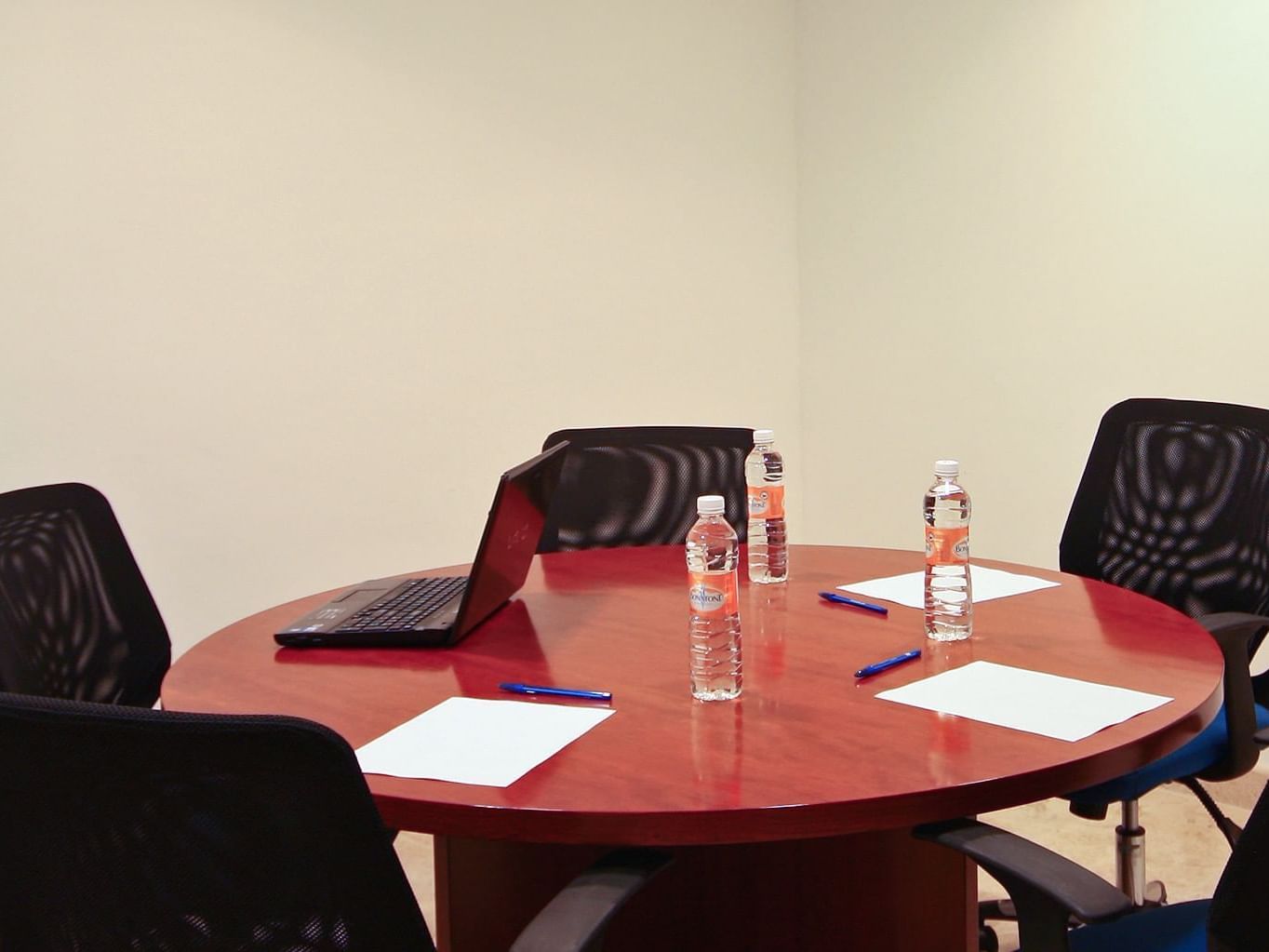 Laptop & water bottles on a meeting table at One Hotels