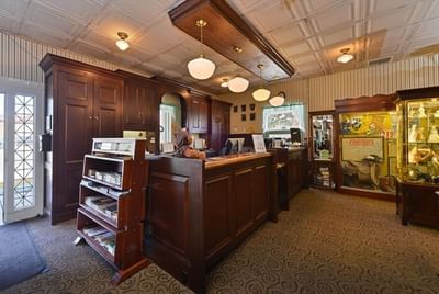 Lobby area with dark wood counters, display cases, and vintage lighting at Buffalo Bill Village