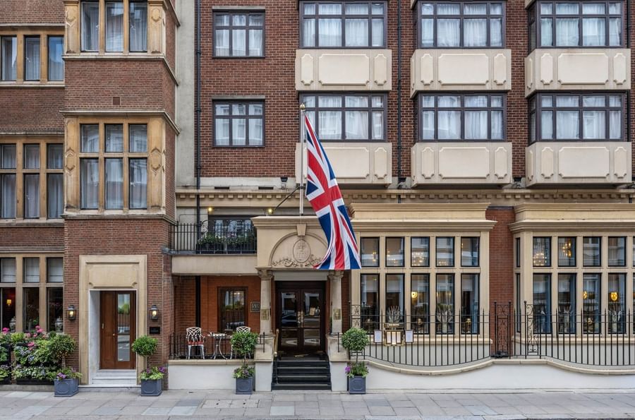 Brick facade of The Capital Hotel, Apartments and Townhouse with a waving British flag over the entrance