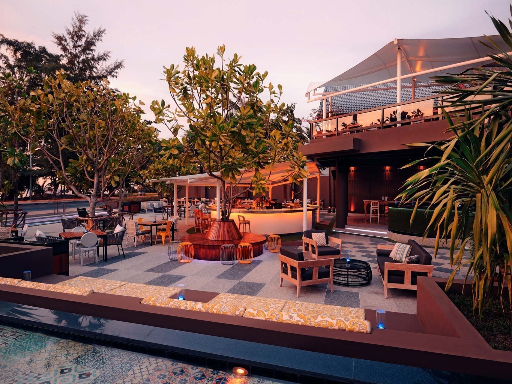 An outdoor dining area by the pool at Paradox Hotels & Resorts