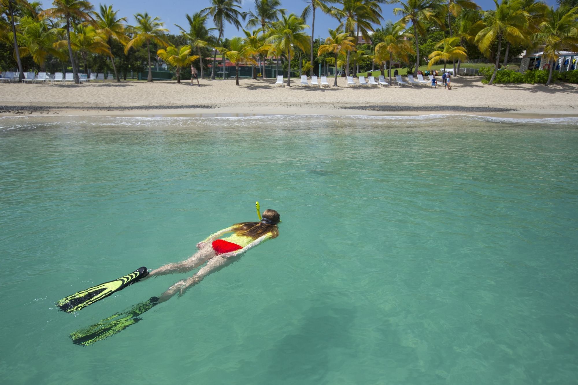 A woman snorkeling in the ocean near The Buccaneer Hotel