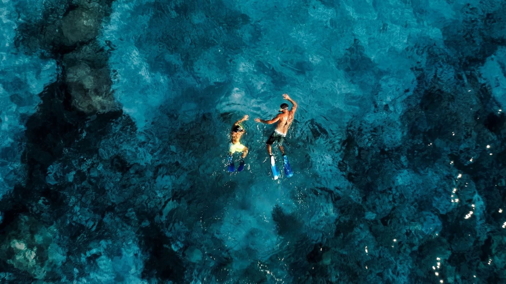 Due subacquei con pinne e maschere galleggiano nell'acqua blu di Falkensteiner Group