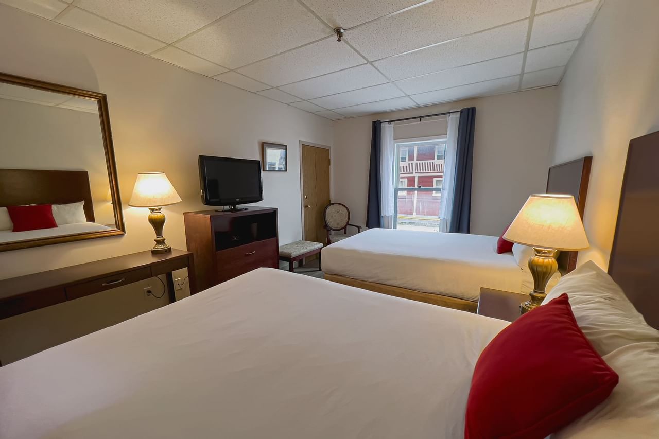 Guest room with two beds, tv, window, mirror, chair