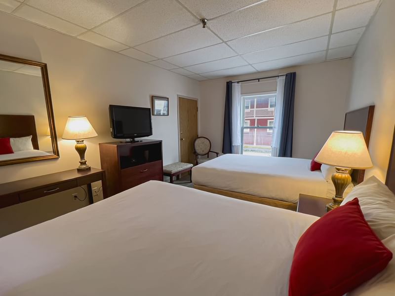 Guest room with two beds, tv, window, mirror, chair