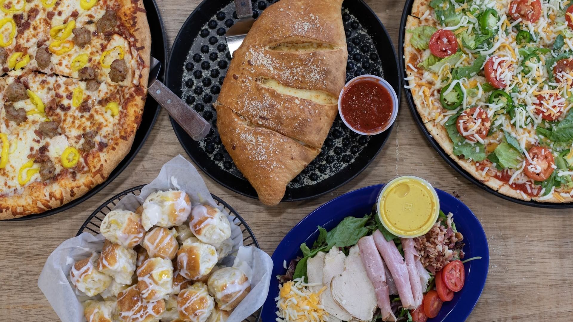 Close-up view of Bruno’s Pizzas with bread and sweets at Watersound Inn