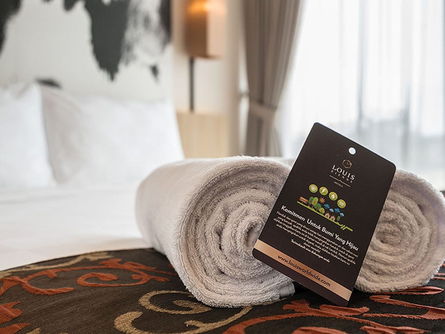 Close-up of rolled towels on the bed in King Bed Deluxe Room at LK Cikarang Hotel & Residences