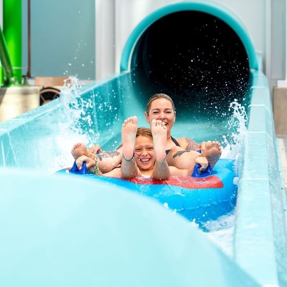 A woman and a child ride a blue tube down a water slide at Showboat Hotel & Resort Atlantic City