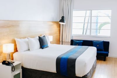 Standard King Room with a bed, couch & lamps at Aqua Hotel