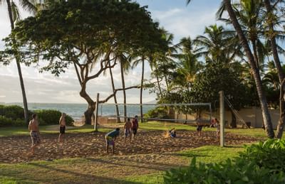Guests playing beach volleyball at Maui Coast Hotel