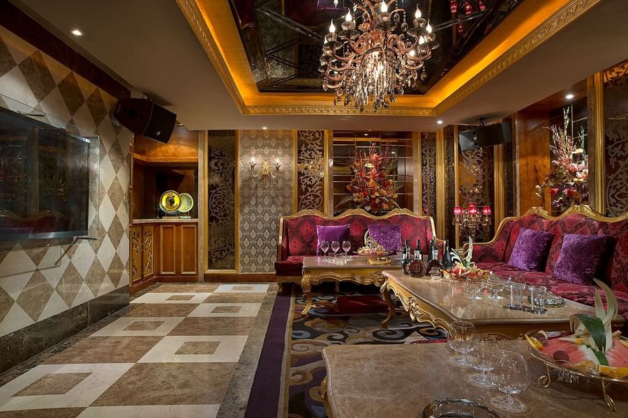 Opulent lounge with velvet sofas under an ornate chandelier at Celebrity International Grand Hotel