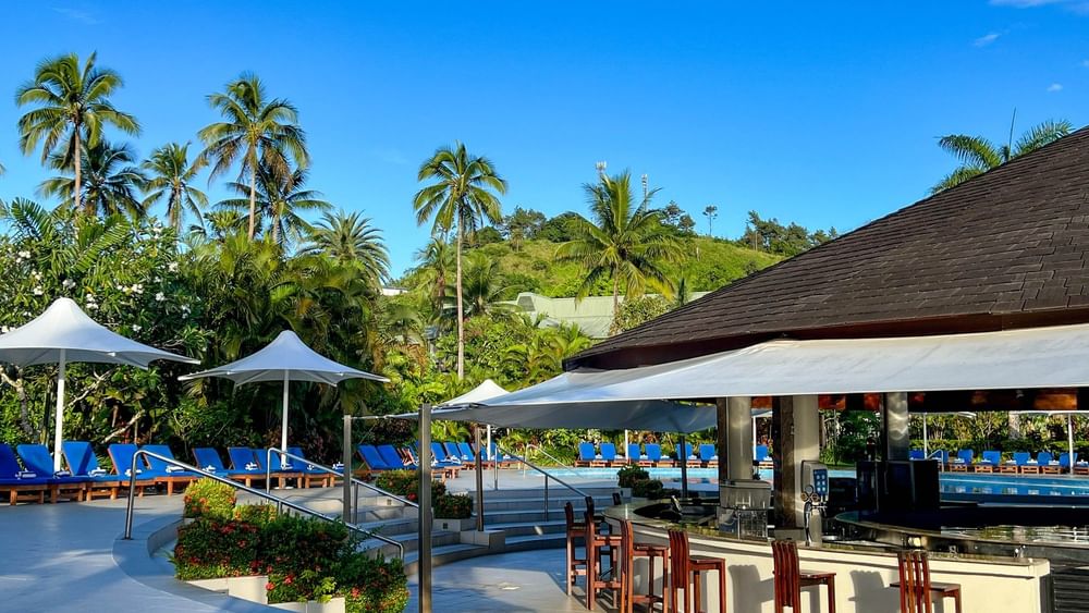 Resort pool area with bar and lounge chairs at The Naviti Resort in Korolevu.