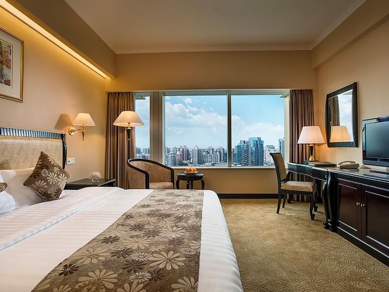 King-size bed, work desk & a TV in Standard Room at Celebrity International Grand Hotel