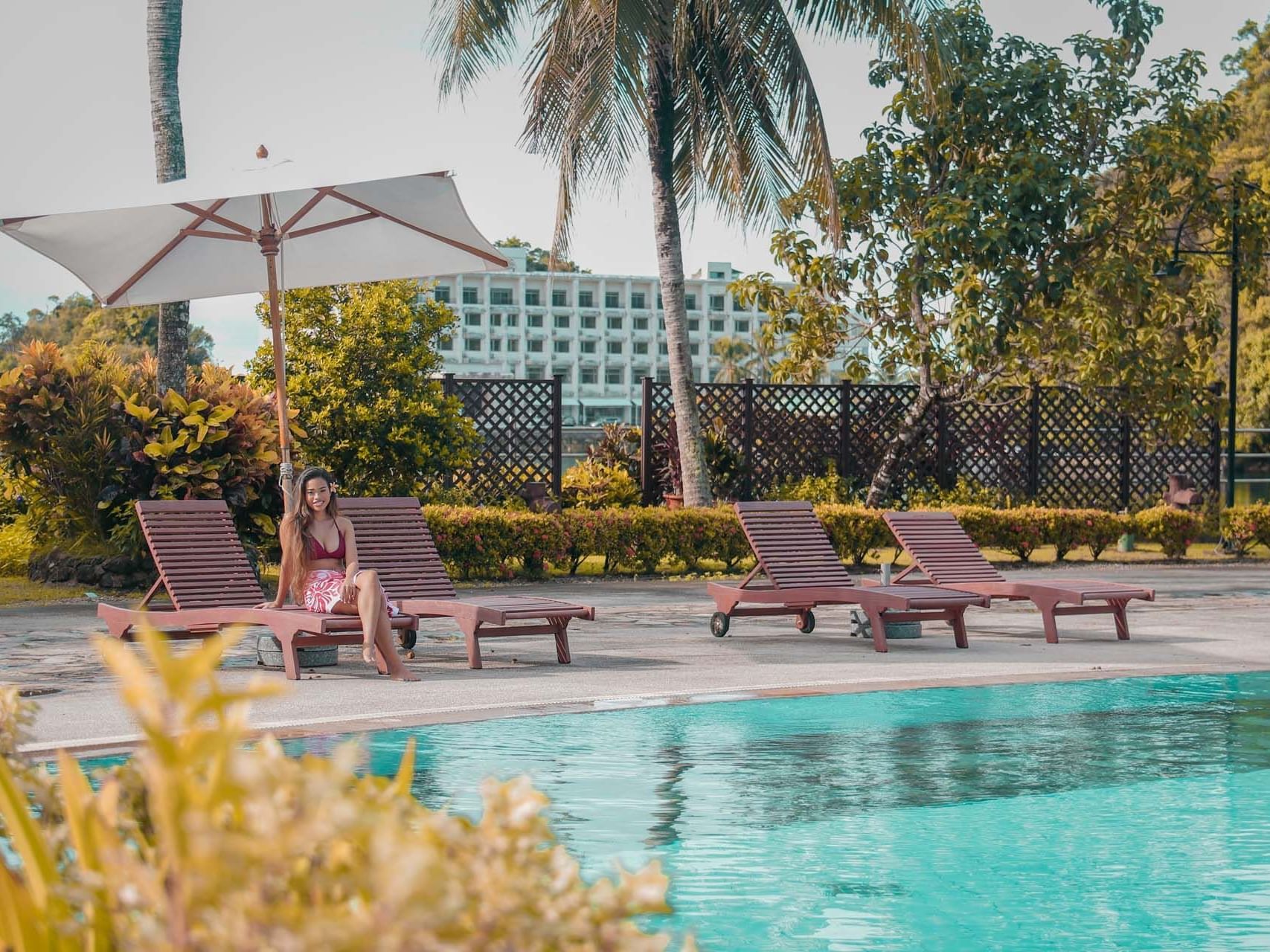 A girl on a lounger near the outdoor pool at Palau Royal Resort