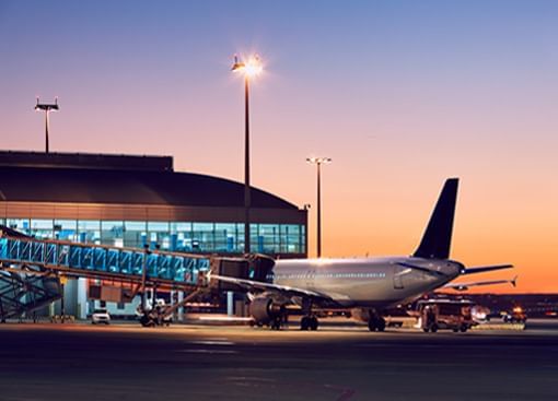 Airplane at a terminal during sunset.