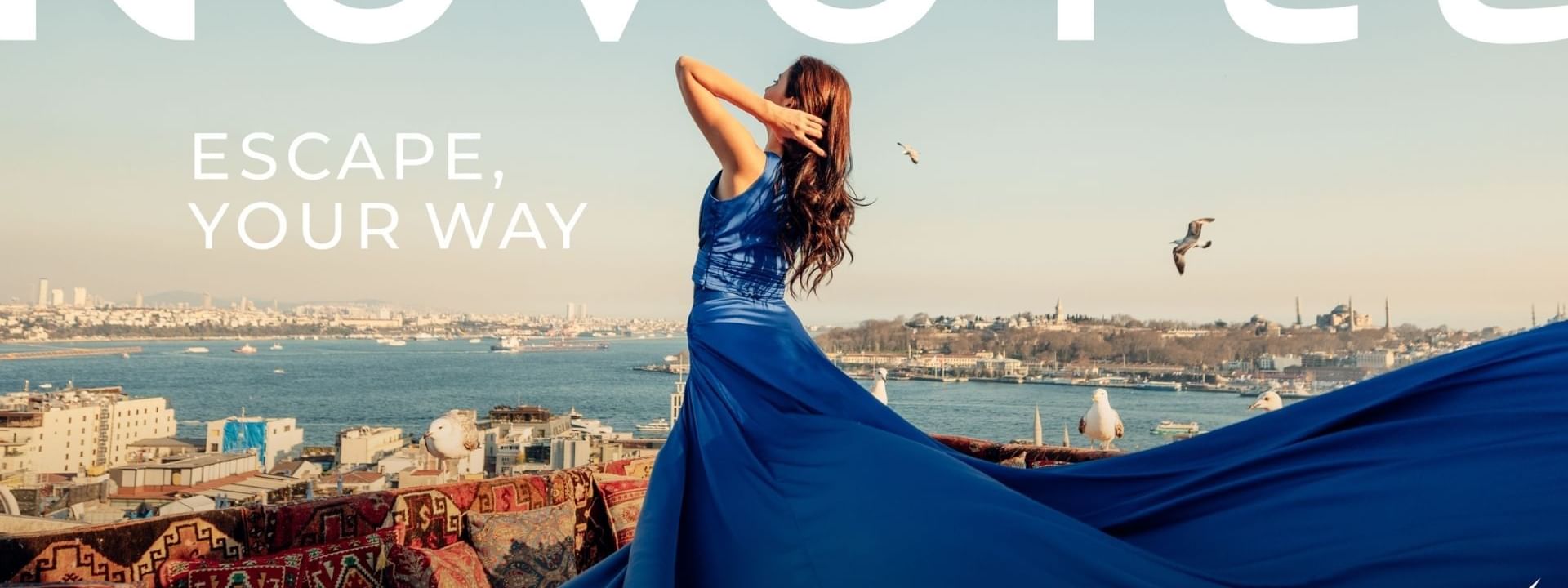 Woman in blue gown stands on rooftop with city view, Novotel advertisement.