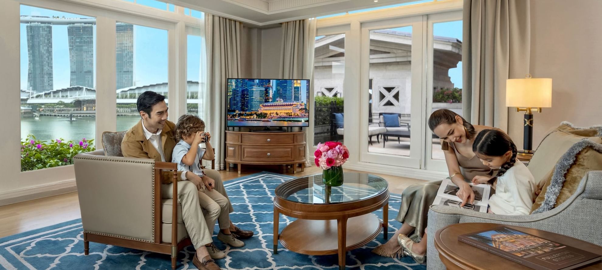 Family enjoying in Fullerton Suite's TV lounge area at The Fullerton Hotel Singapore