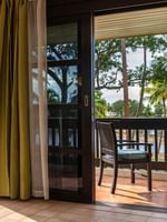Wooden chairs on a tiled balcony by a sliding glass door in suites at The Naviti Resort in Korolevu.