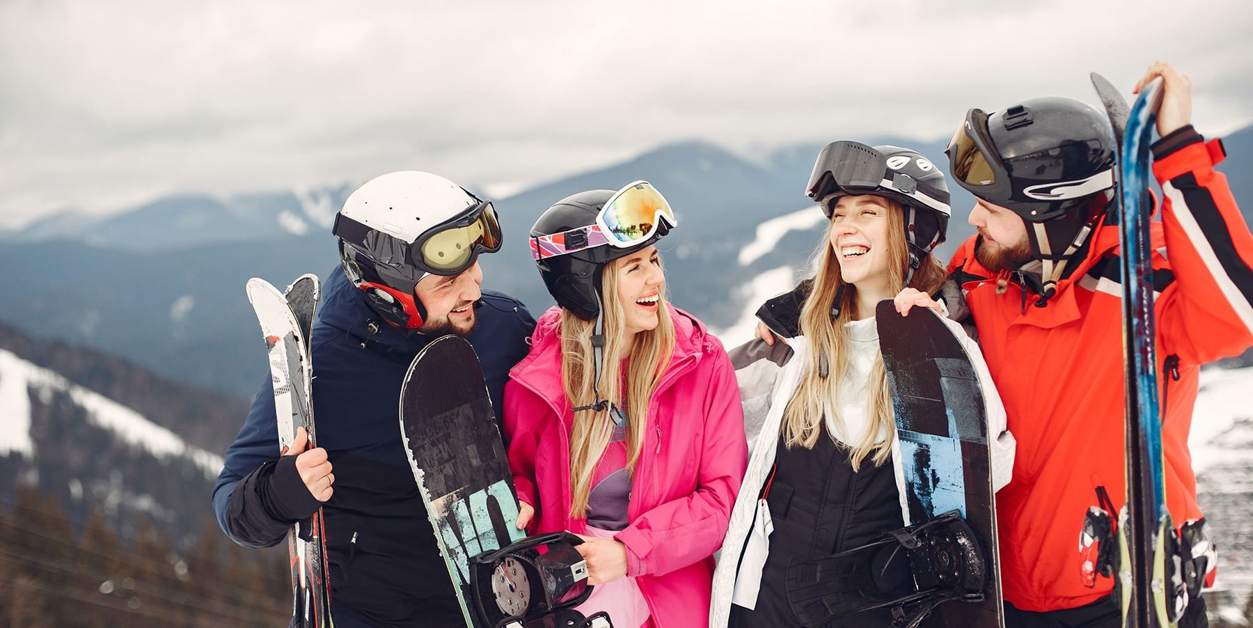 Group of skiers and snowboarders holding equipment on a mountain slope near Listel Whistler, a Coast Hotel