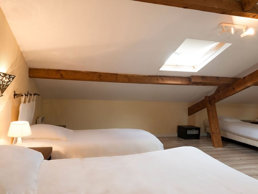 Twin Beds in a room at Hotel Le Cheval Rouge