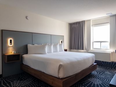 Comfortable hotel room with a bed and a window at Carriage House Hotel & Conference Centre