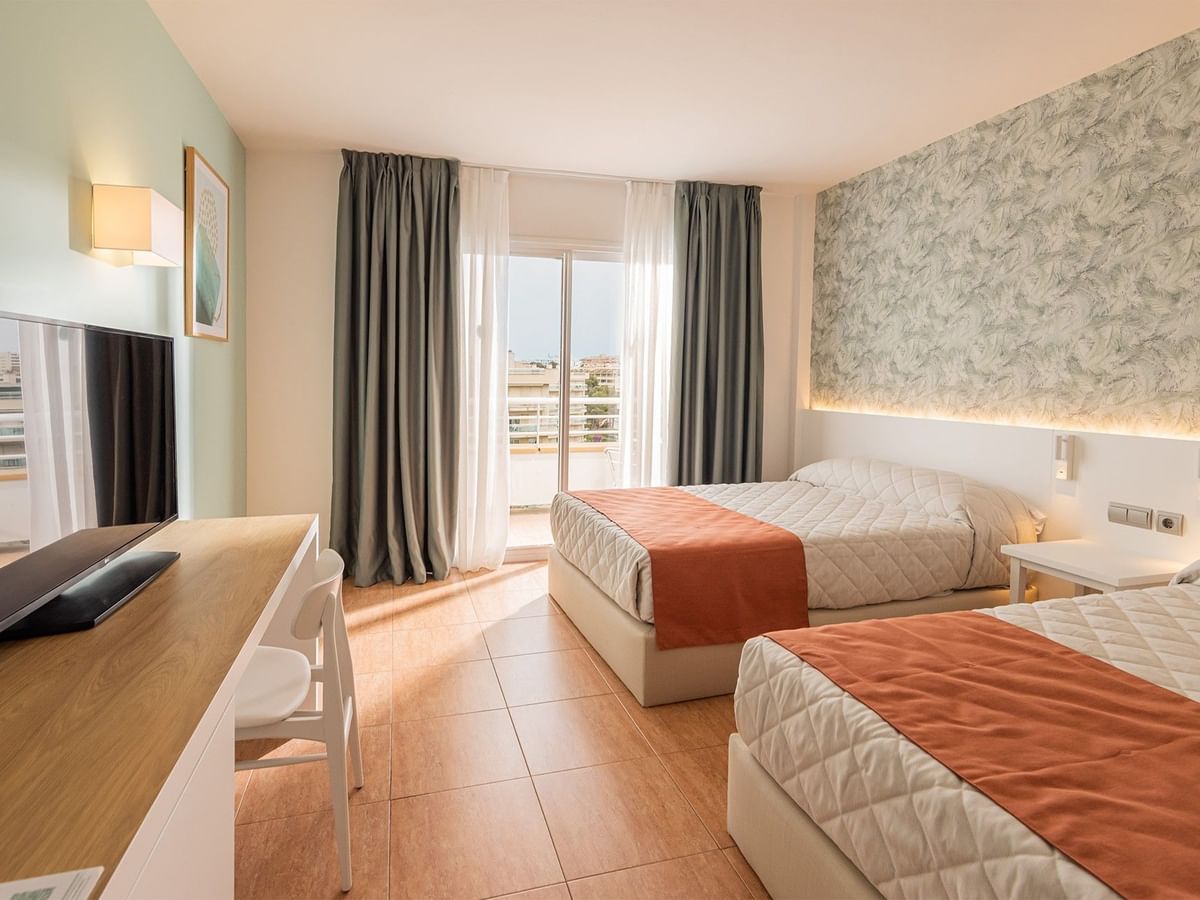 Two comfy beds with TV area in Standard Room at Ponient Pirámide Salou