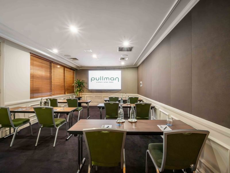 Classroom set-up with projector screen in Dalley Room at Pullman Sydney Hyde Park