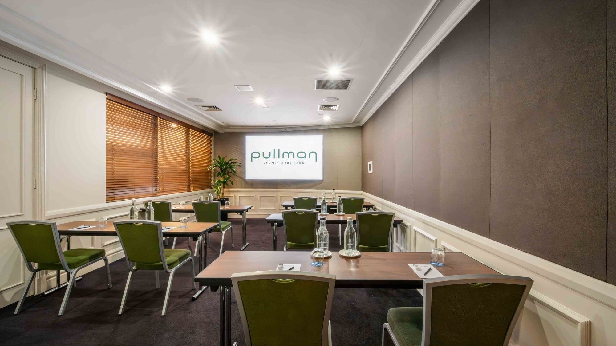 Classroom set-up with projector screen in Dalley Room at Pullman Sydney Hyde Park