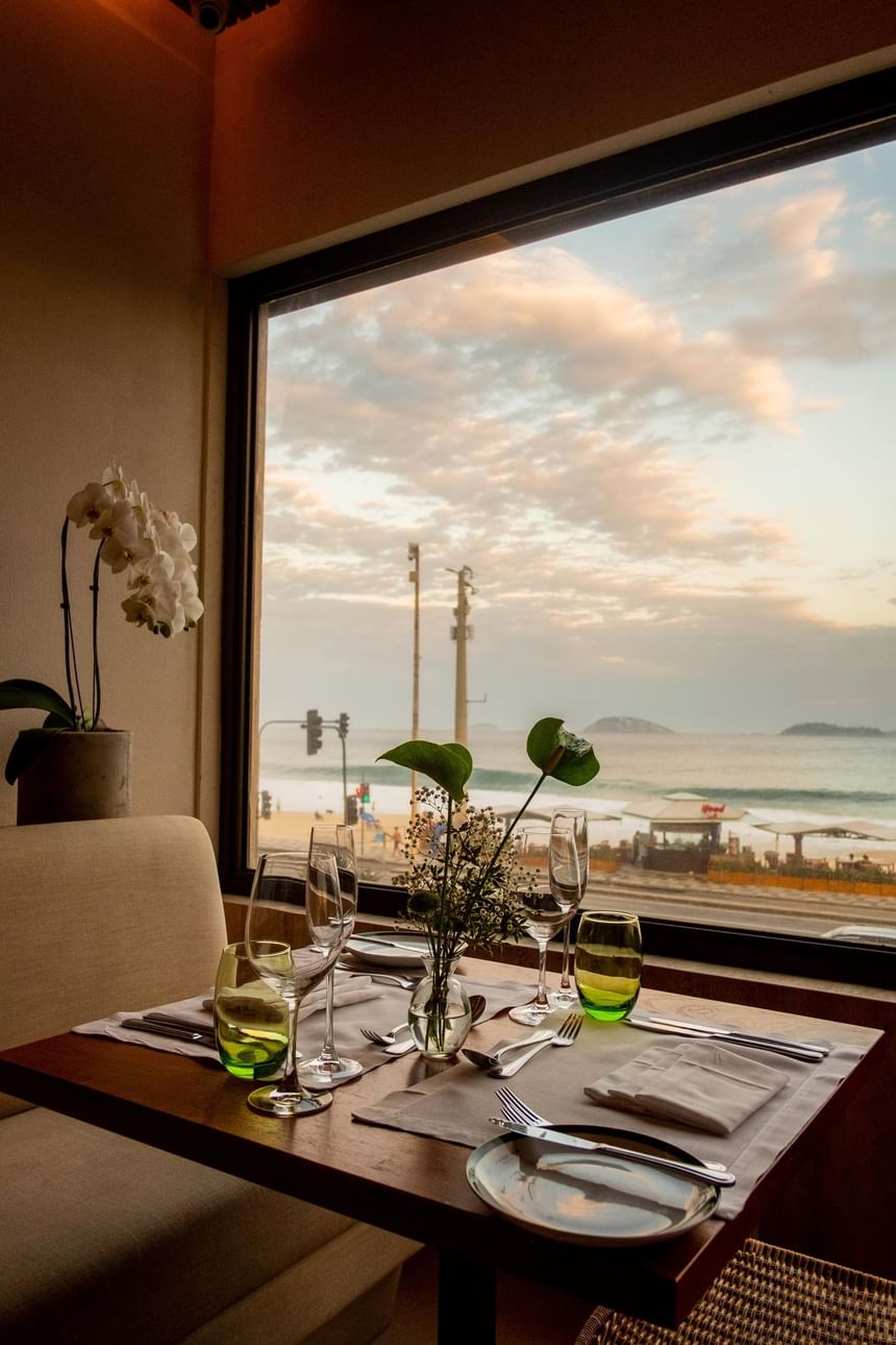 Mesa arrumada para uma refeição de restaurante novo no Leblon com vista para o mar 