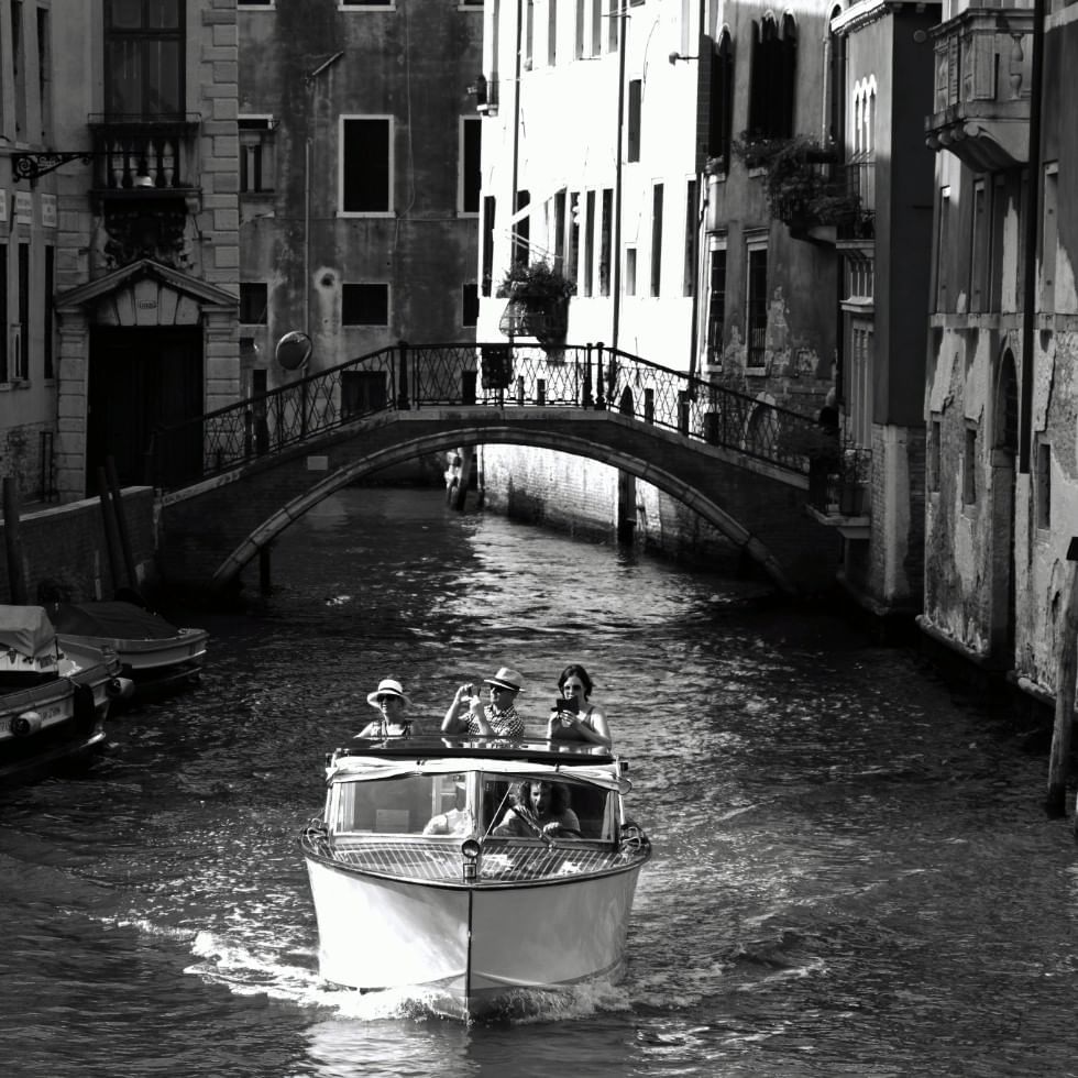 Tourists sailing through Venice near Falkensteiner Hotels