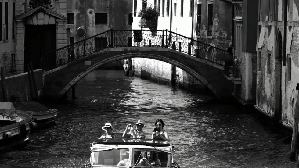 Tourists sailing through Venice near Falkensteiner Hotels