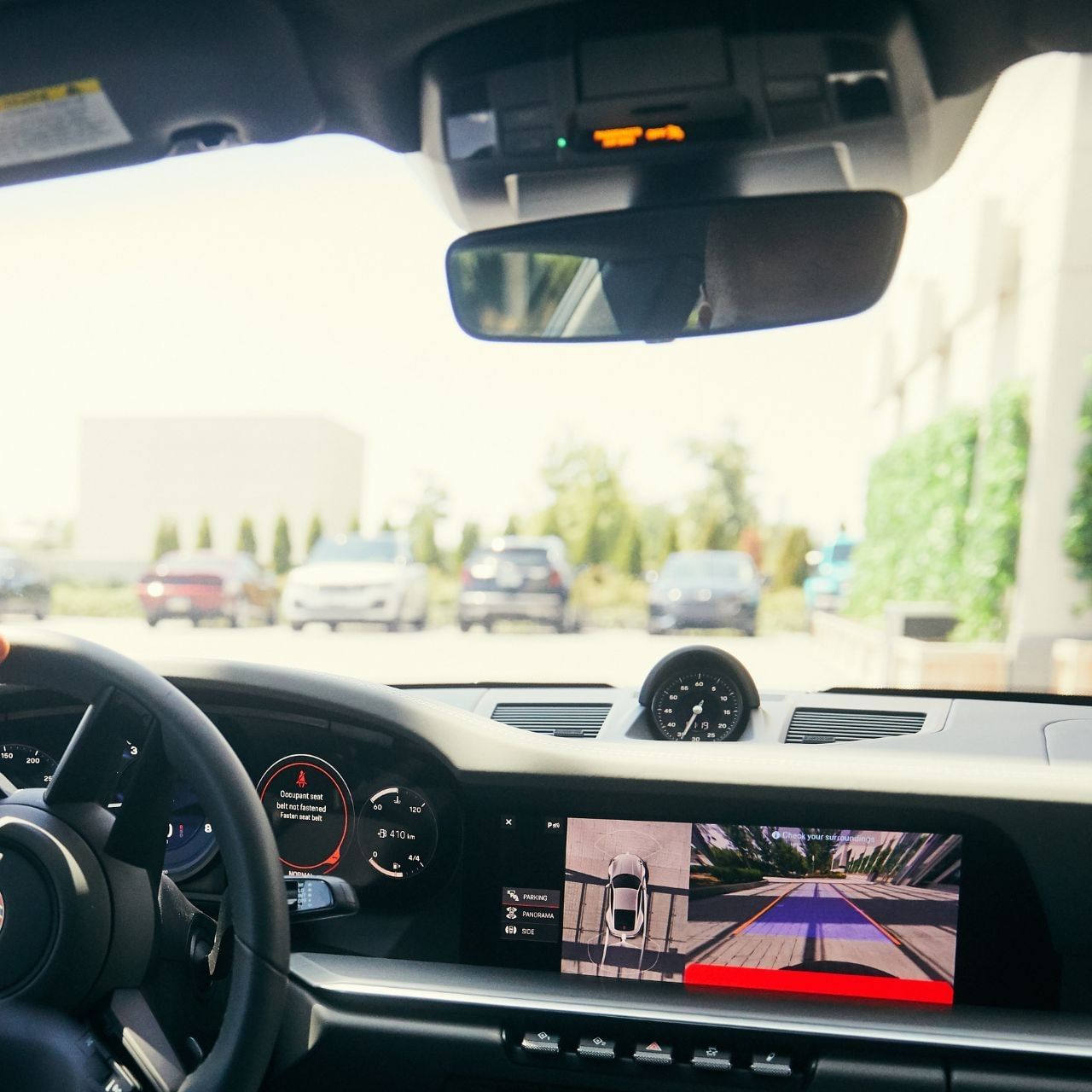 Car\'s rearview camera display showing a parking lot view, by the steering wheel near Hotel X Toronto