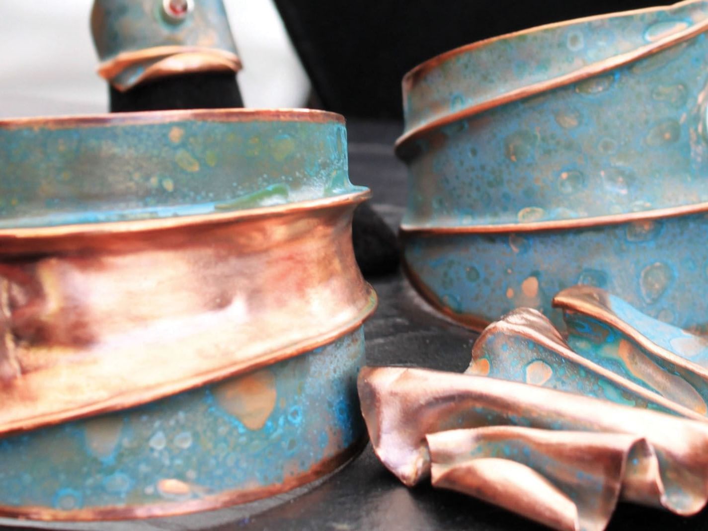Close-up of handcrafted copper jewelry display near The Embers Hotel
