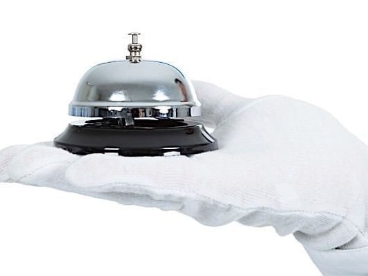 A butler holding a service bell at Casa Colonial Beach and Spa