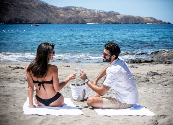 Couple enjoying wine on the Beach near Villas Sol Beach Resort
