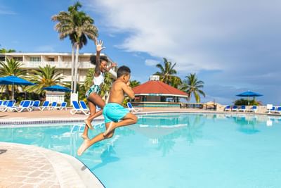 Two kids jumping into the pool at Holiday Inn Montego Bay