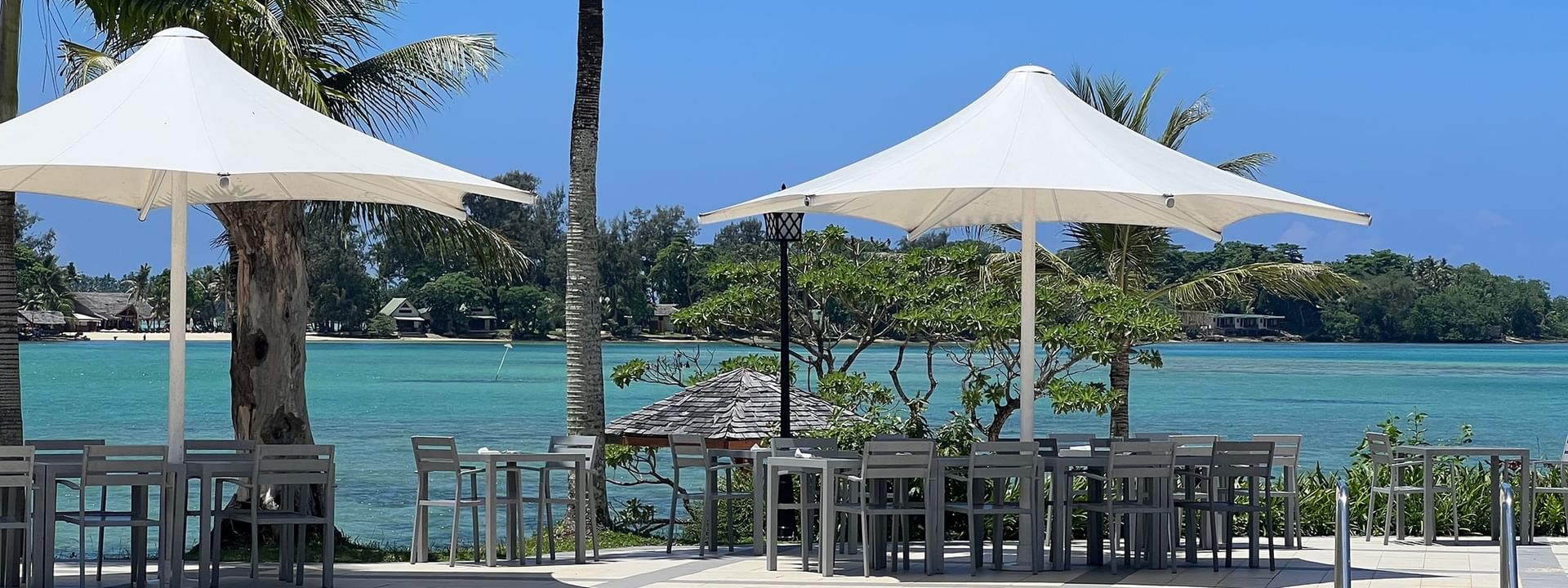 Tables and umbrellas near a swimming pool at Warwick Le Lagon - Vanuatu in Efate
