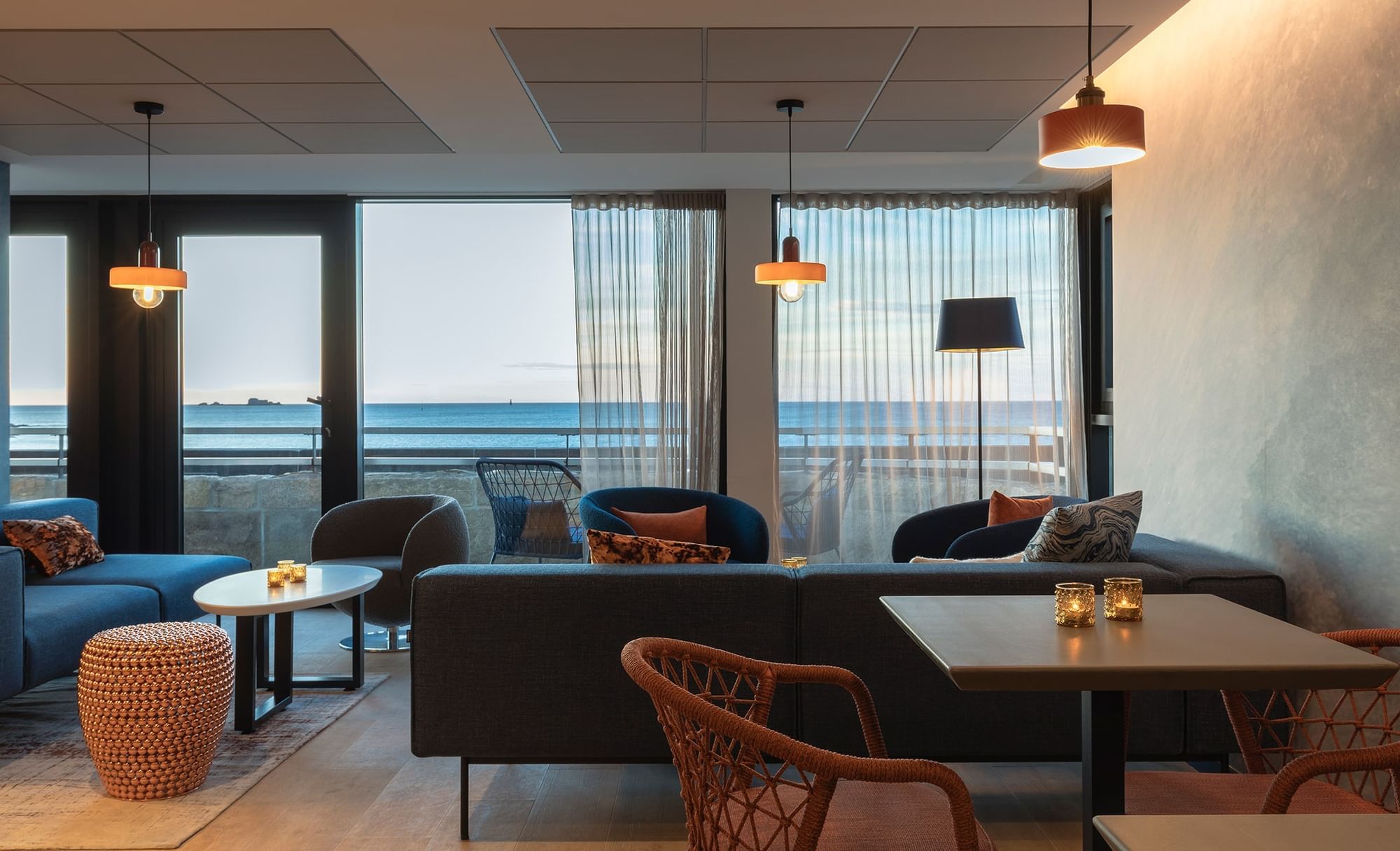 Coin salon avec canapés et tables basses avec vue sur la mer à l'Oceania Saint-Malo