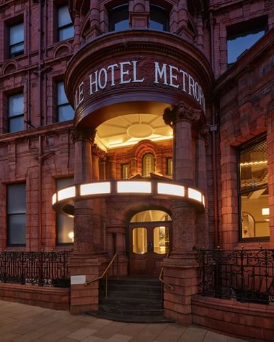 The Met Hotel Leeds, England, exterior featuring its historic Victorian red-brick facade illuminated at dusk